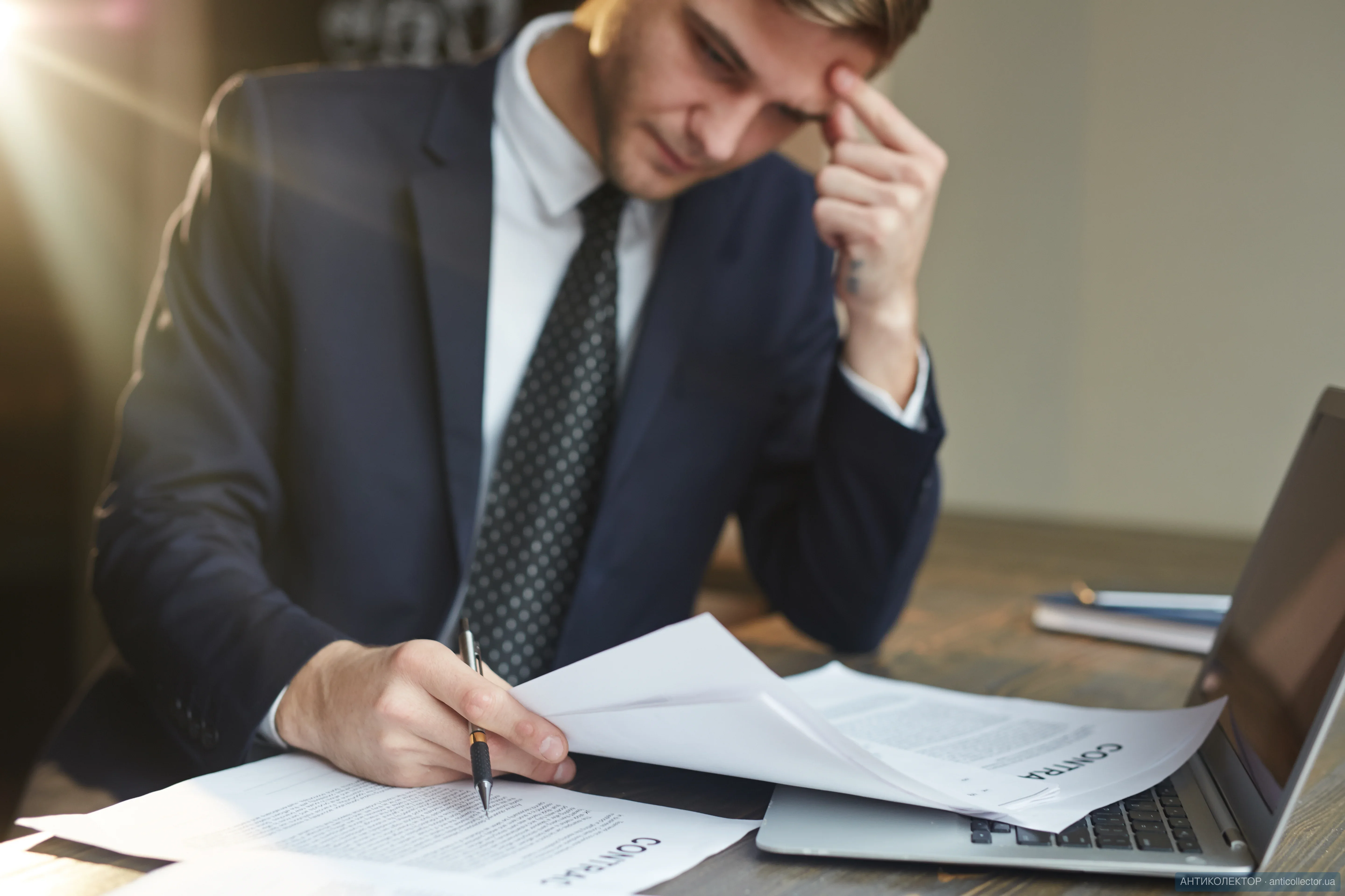 stressed-businessman-working-with-contract-documents.webp