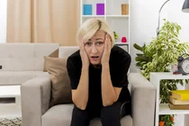 anxious-beautiful-blonde-woman-sits-armchair-holding-head-inside-design-living-room (1).webp